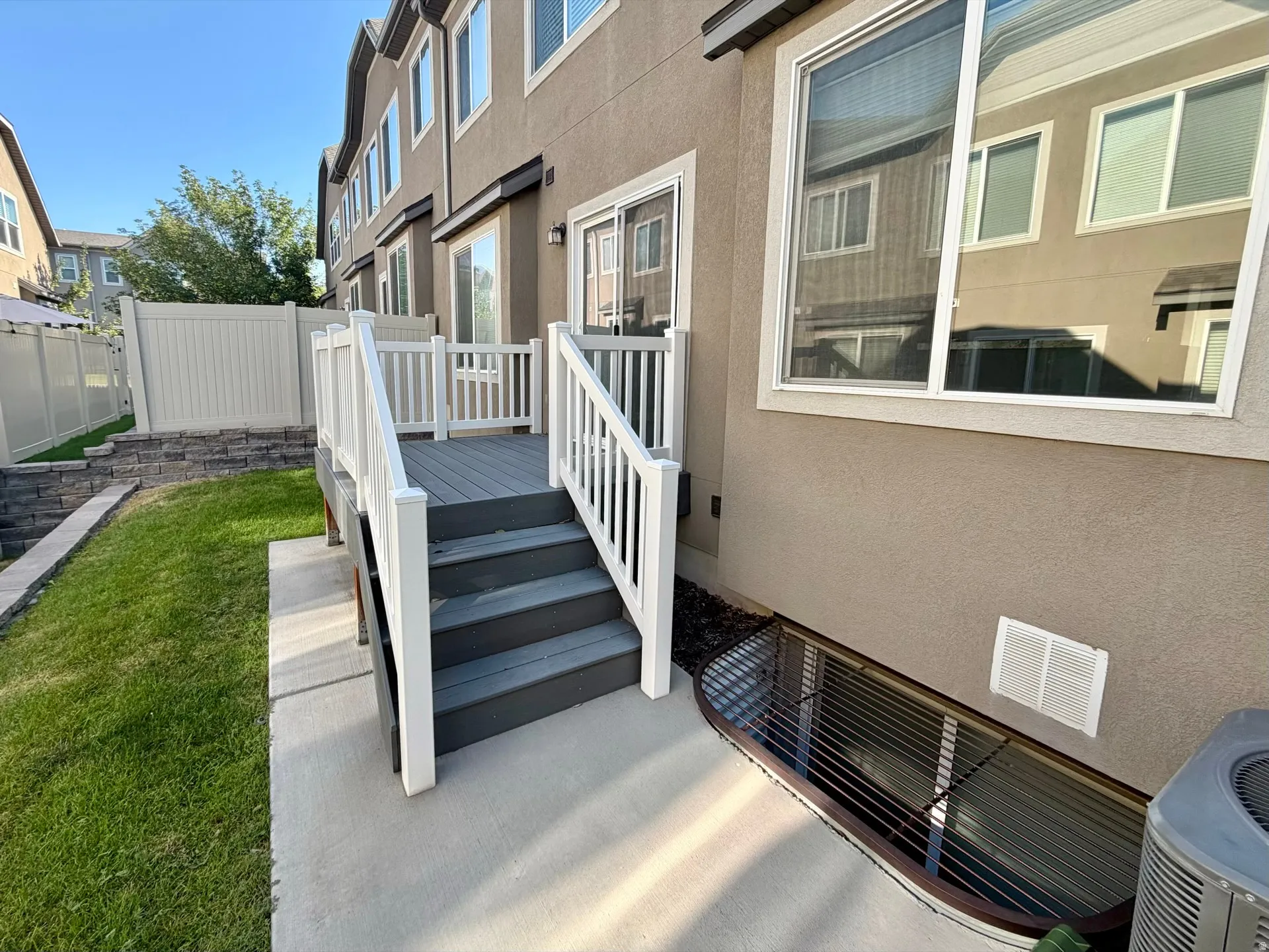 Private rear patio deck with stairs to a concrete landing