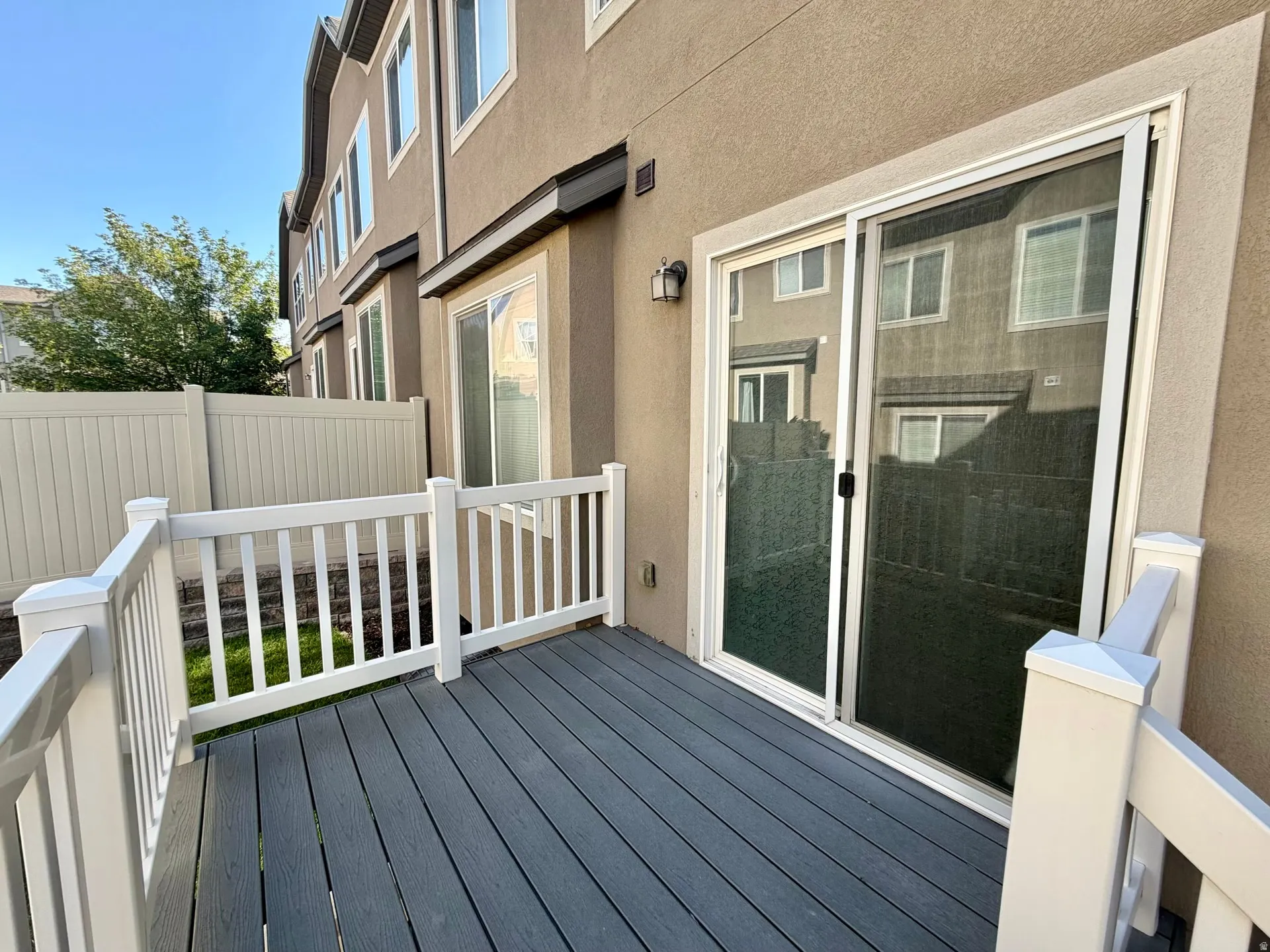 Private deck featuring composite wood-finish flooring and white railings