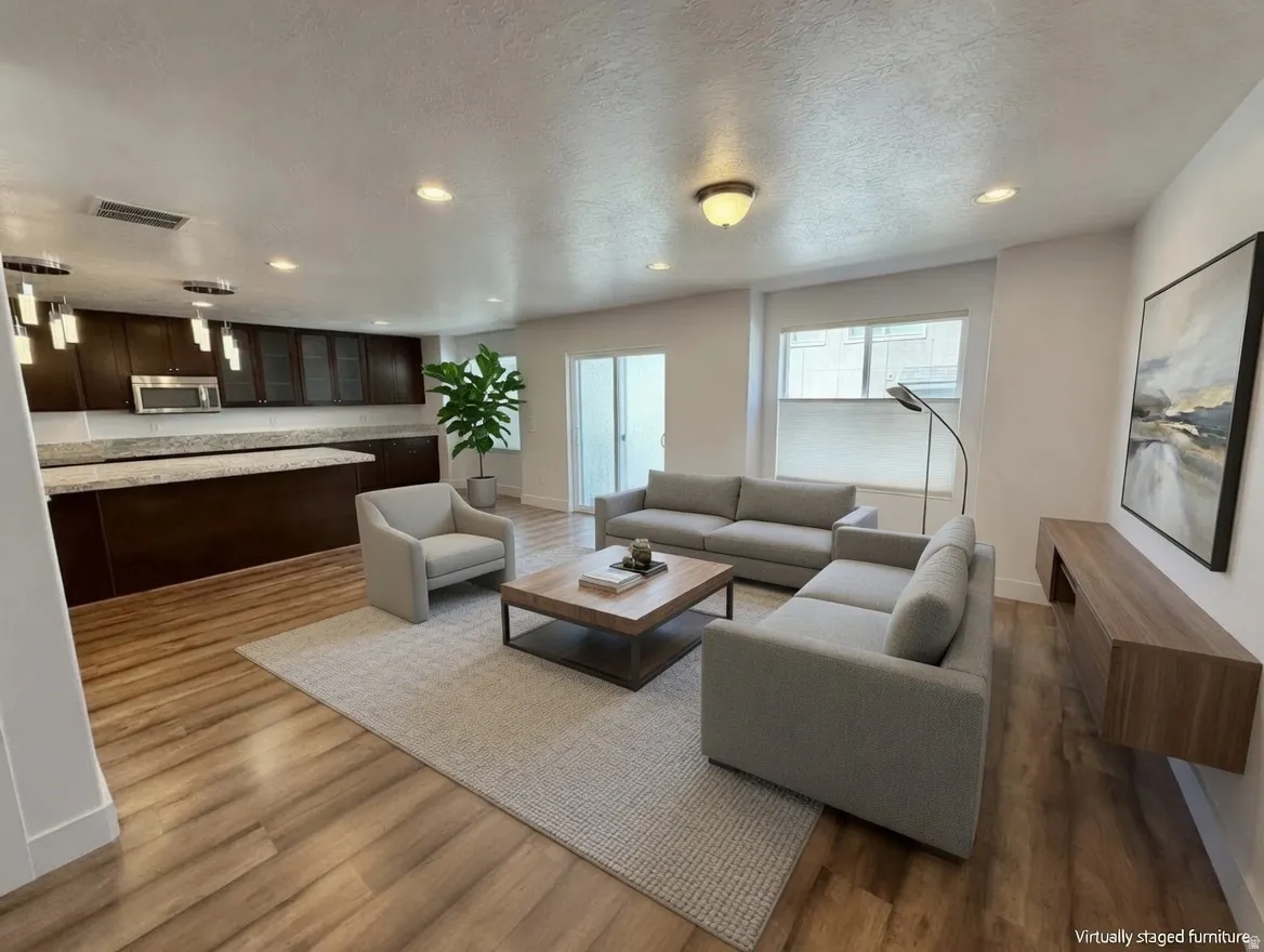 Open-concept living space featuring wood-finish flooring and recessed lighting