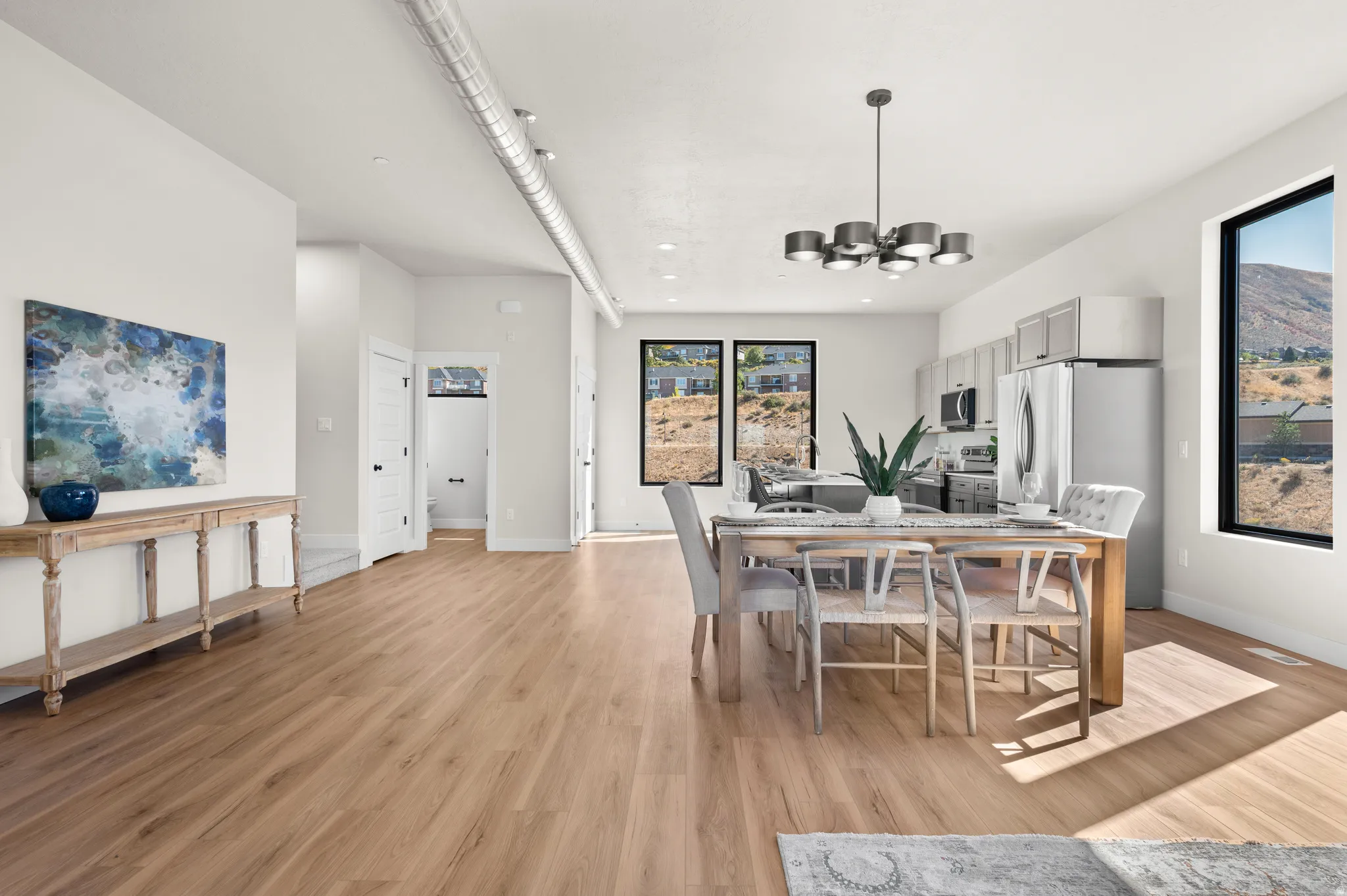 Open-concept living space featuring wood-finish flooring, recessed lighting, and a visible HVAC duct