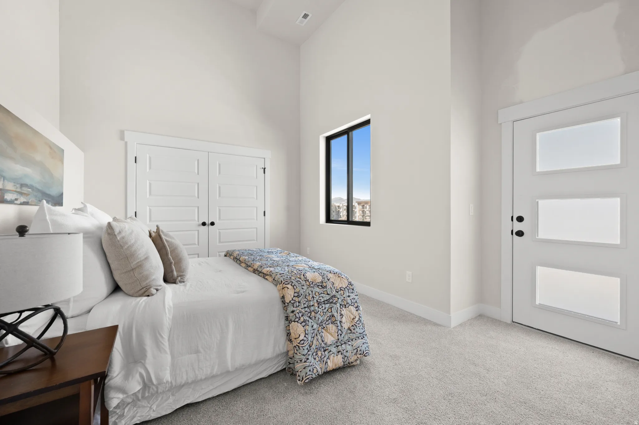 Vaulted ceiling bedroom with light gray carpet flooring