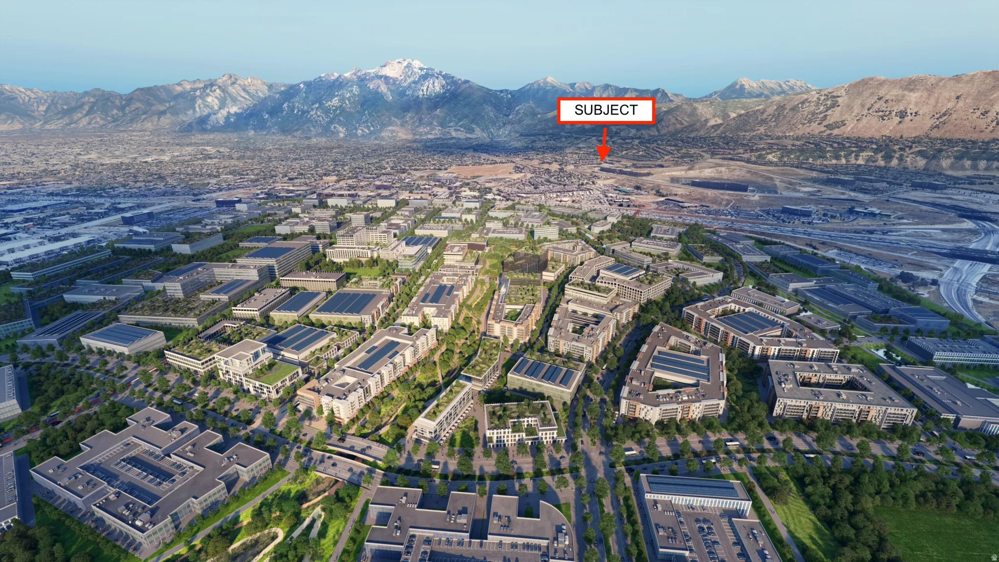 Expansive urban development featuring varied building complexes, green spaces, and a mountainous backdrop