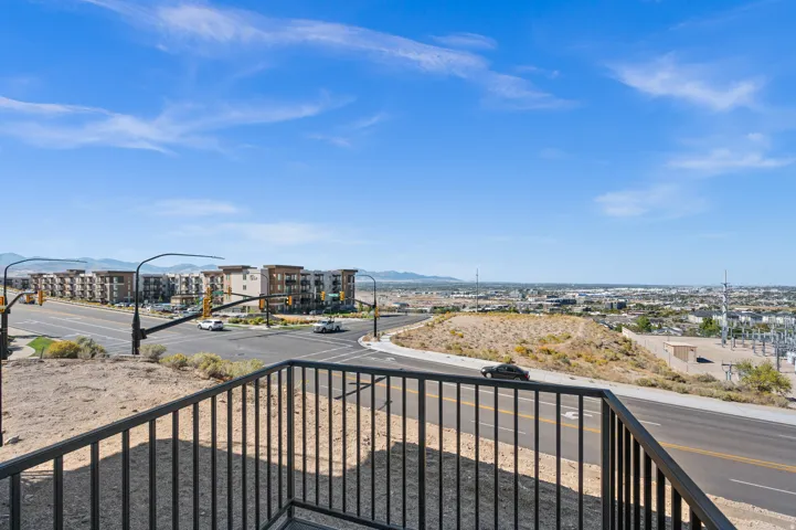 Expansive outdoor space featuring a black metal railing and elevated views of the surrounding urban and natural landscape