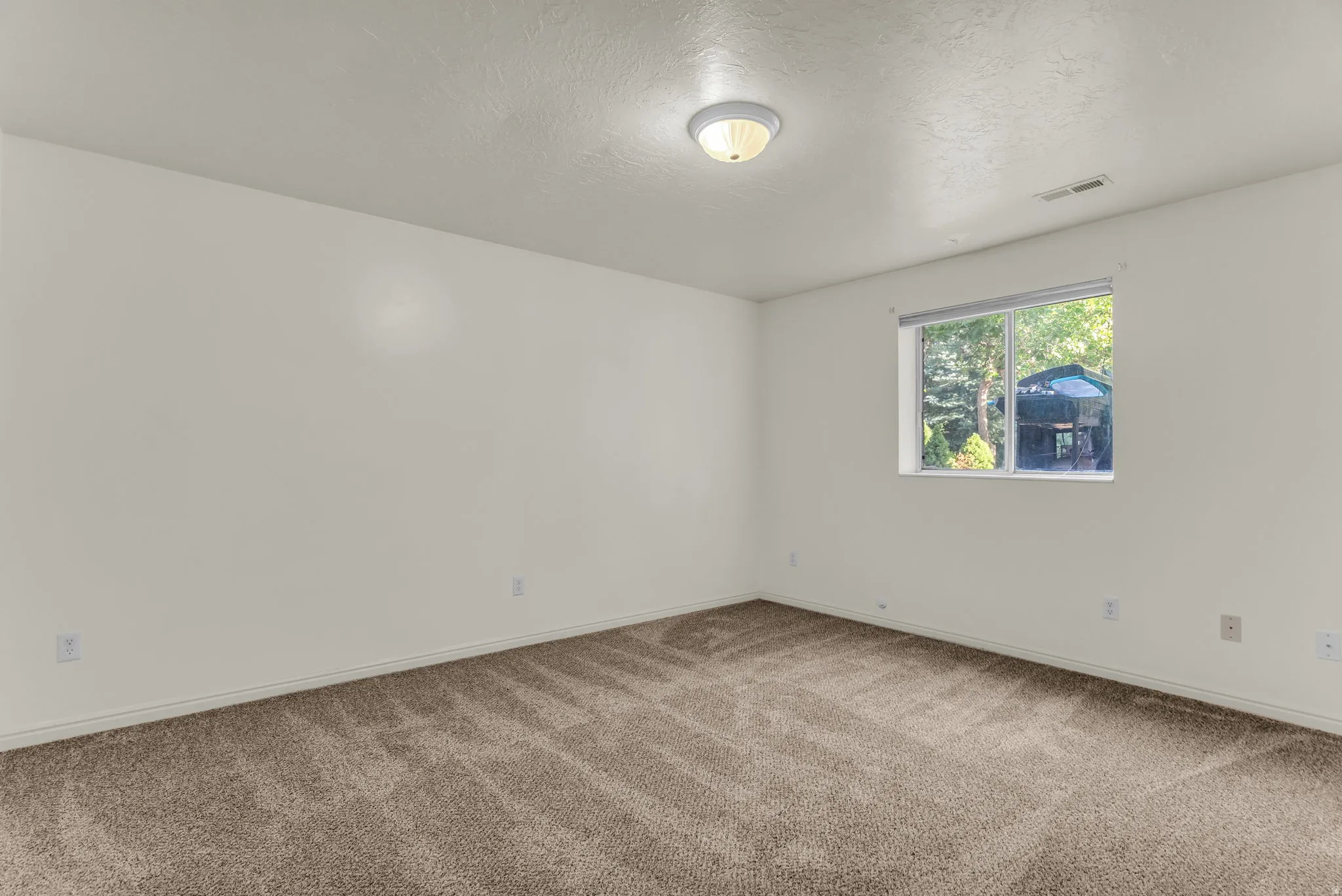 Neutral-toned wall-to-wall carpeting complements the light wall color