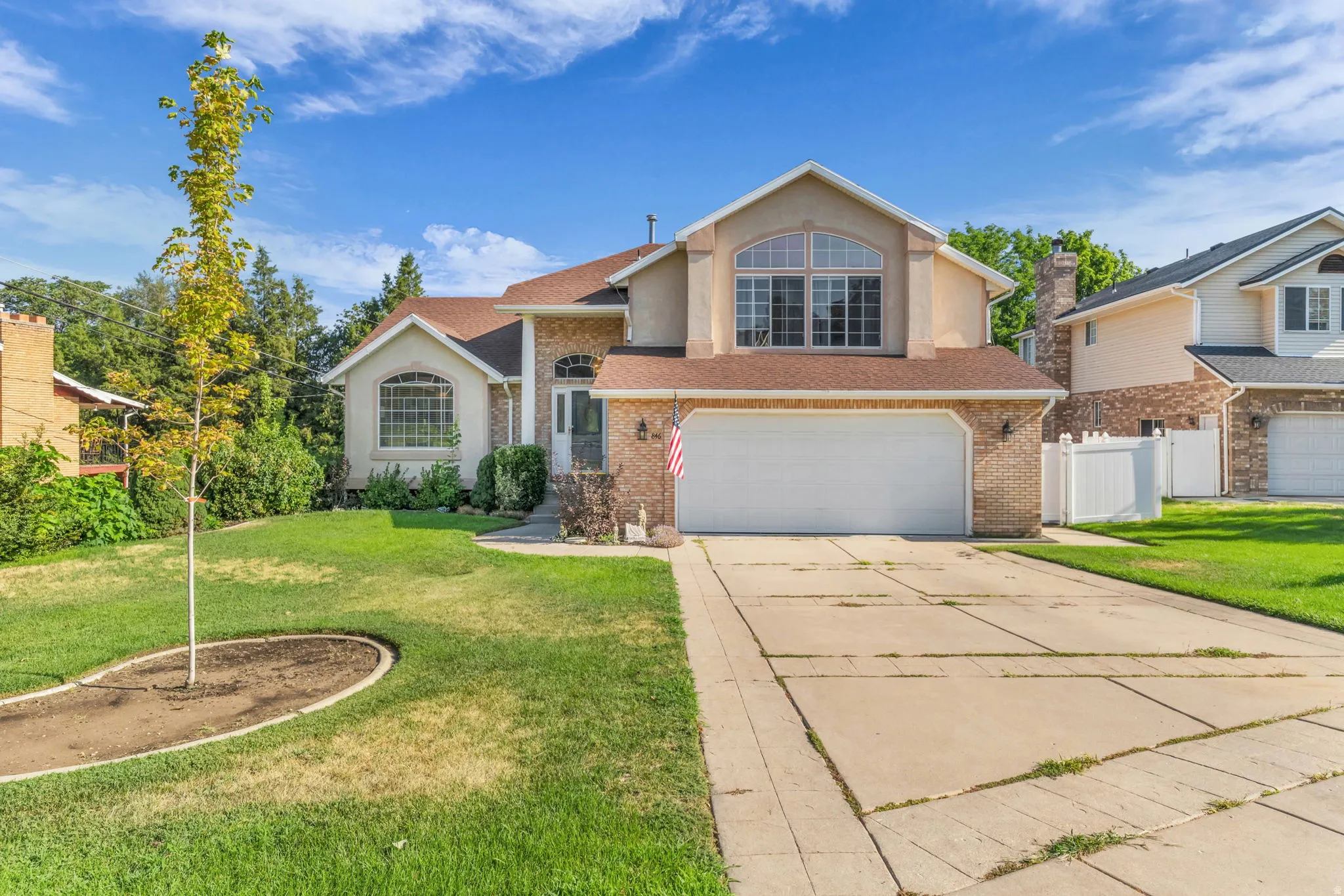 Traditional style home featuring a partial brick facade, stucco siding, and an attached two-car garage