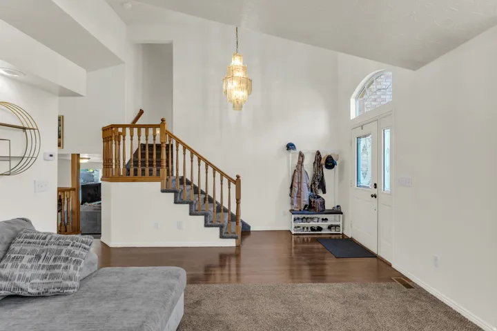 Inviting entryway with a vaulted ceiling and a tiered chandelier