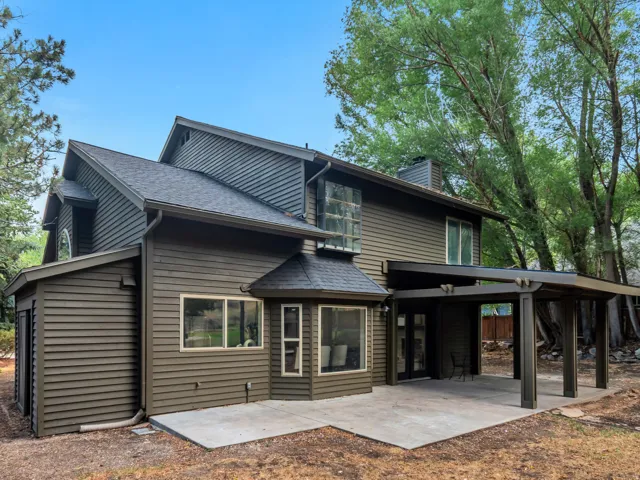 Rear exterior featuring horizontal siding, a covered patio structure, and a concrete patio