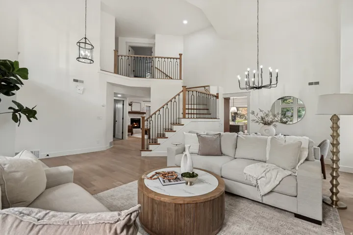 Vaulted ceiling living space with light wood-finish flooring