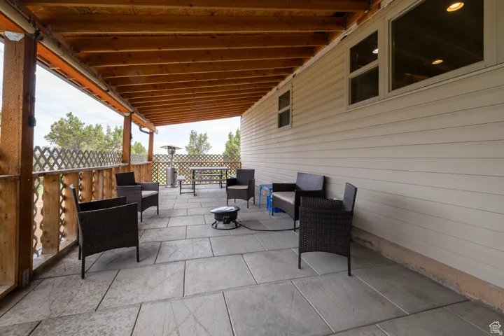 Covered outdoor patio featuring large format tile flooring and a natural wood ceiling
