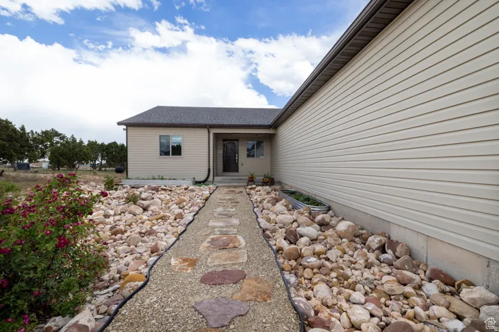Exterior showcasing neutral-toned siding and a dark shingle roof