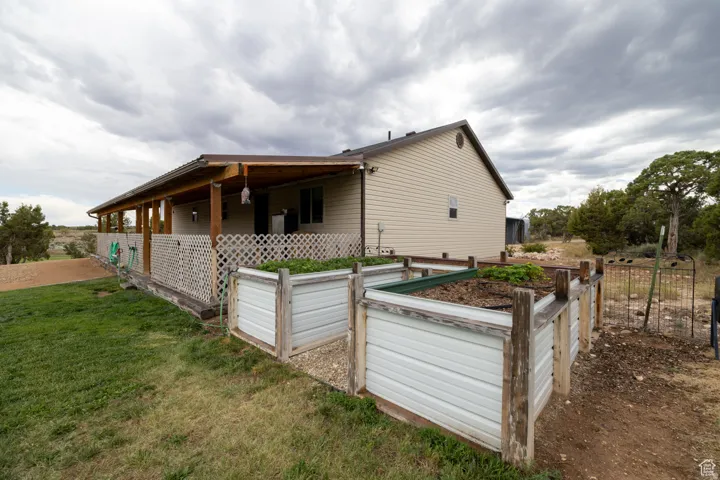 Side exterior featuring a covered porch, wood posts, and lattice skirting