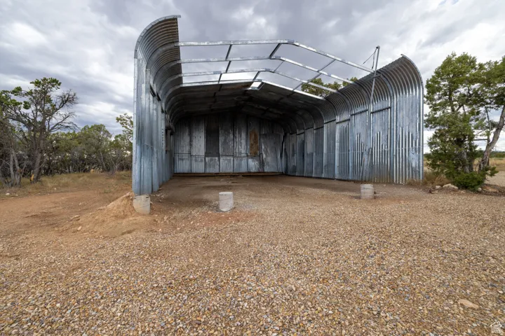 Corrugated metal quonset structure with partial roofing and open-ended design