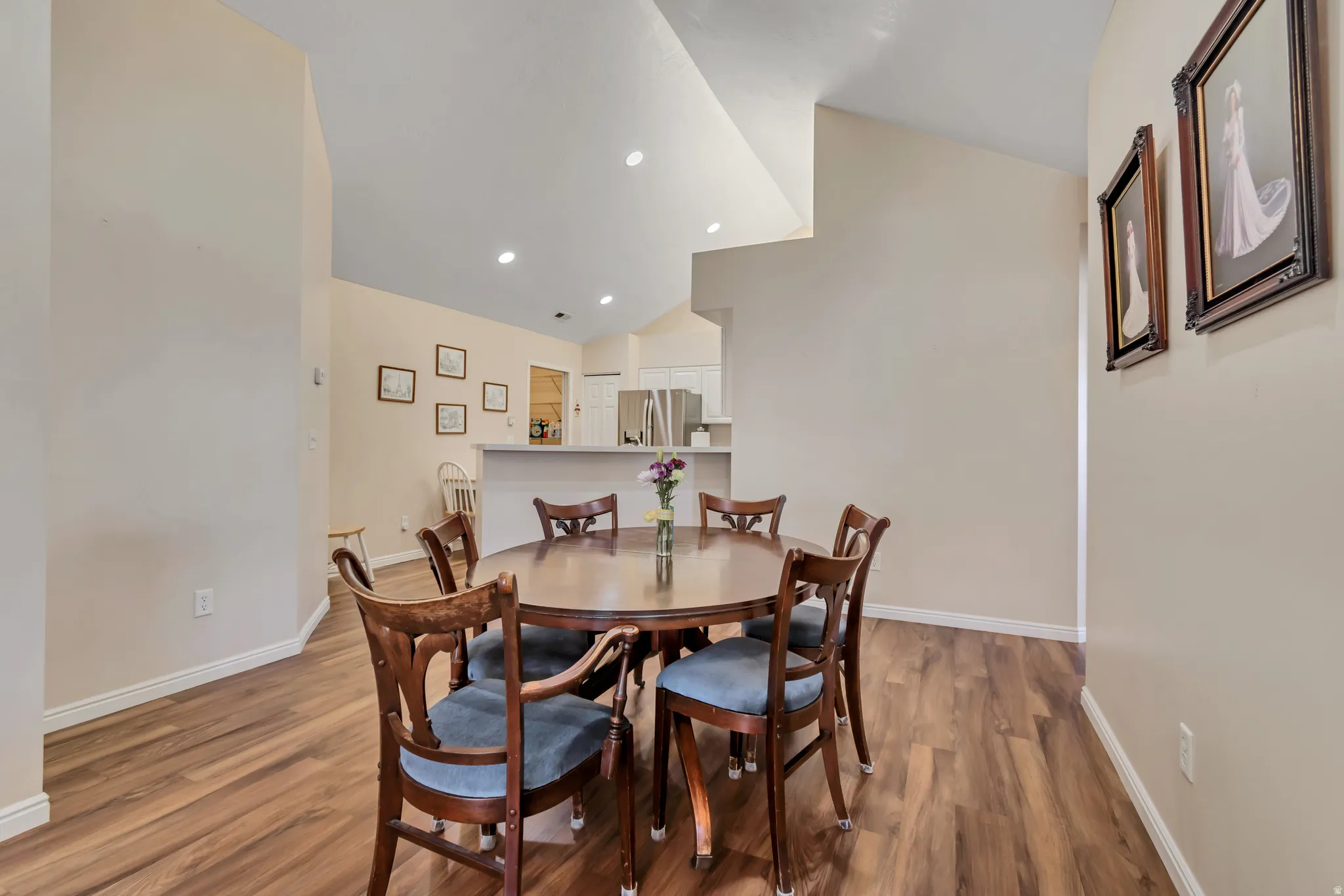 Spacious dining area featuring wood-finish flooring, vaulted ceilings, and recessed lighting