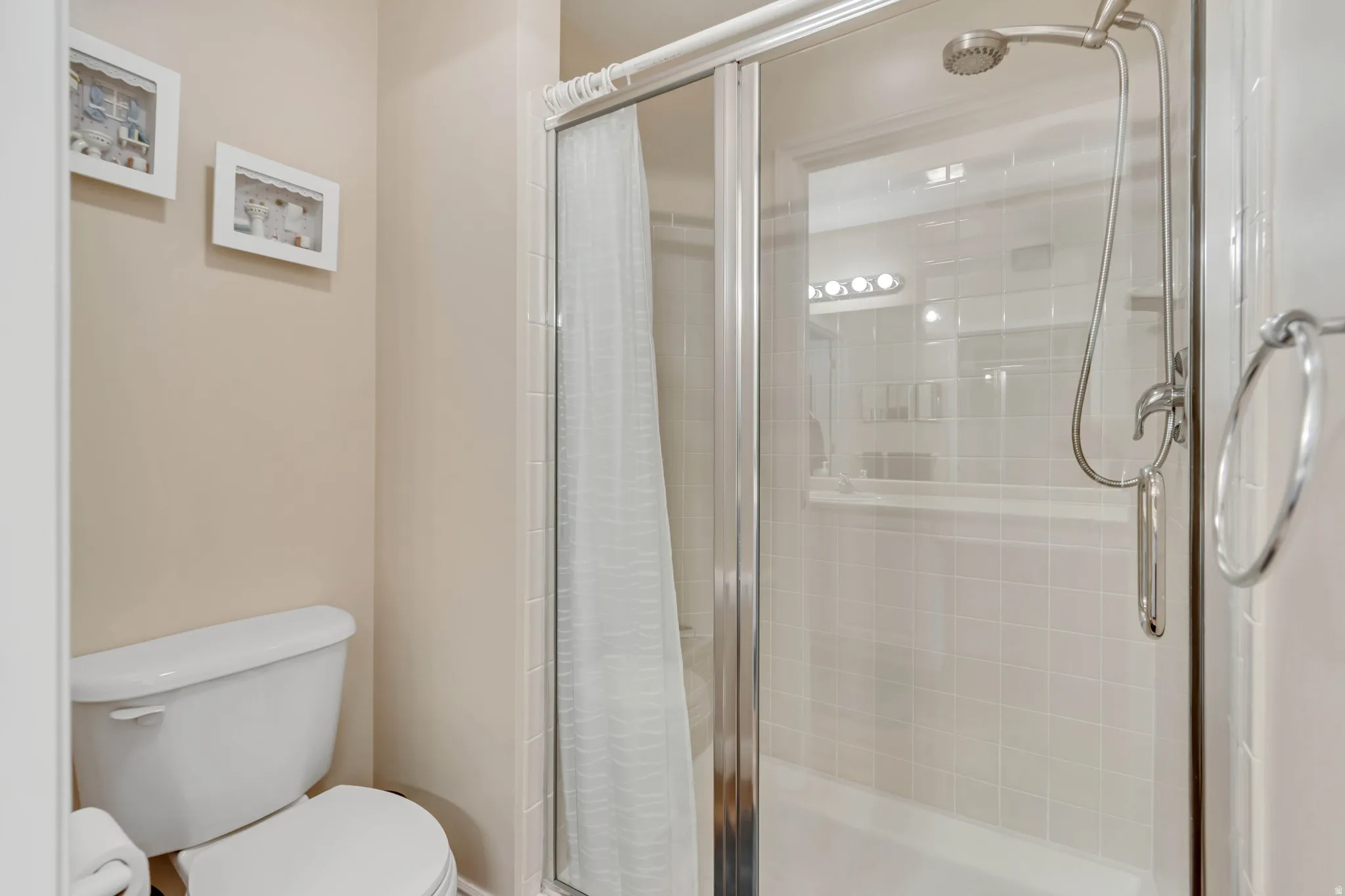 Enclosed shower with clear glass door, subway tile surround, and built-in shower niche
