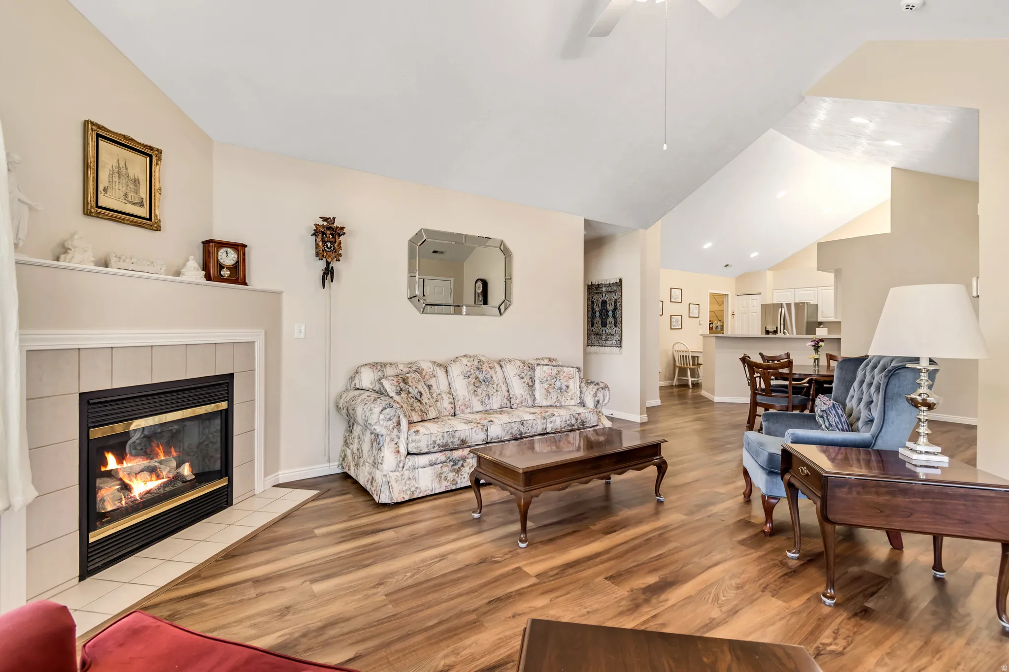 Living area featuring vaulted ceilings, wood-finish flooring, and a tile-surround fireplace