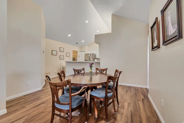 Spacious dining area featuring wood-finish flooring, vaulted ceilings, and recessed lighting