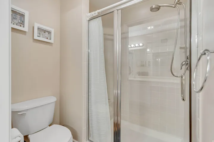 Enclosed shower with clear glass door, subway tile surround, and built-in shower niche