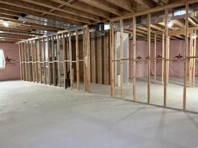 Unfinished basement featuring wood framing and concrete flooring