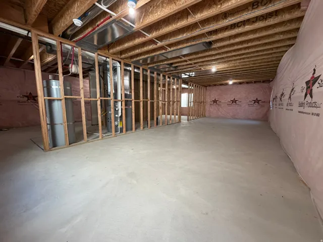 Unfinished basement with concrete flooring and exposed wood framing