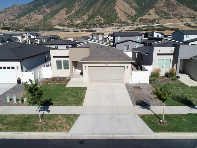 Contemporary-style residence featuring a tan stucco exterior, an attached garage, and a concrete driveway