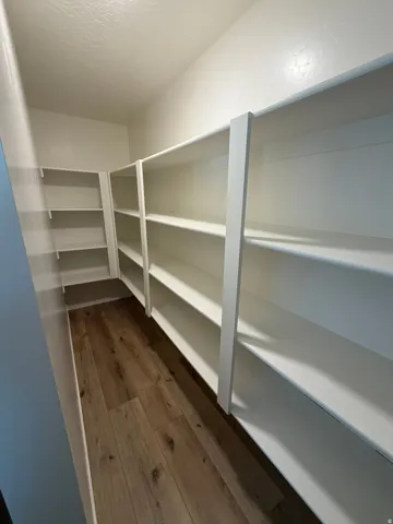 Walk-in pantry featuring extensive white shelving