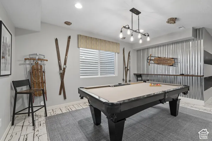 Recreational space featuring a pool table, wood-finish flooring, and a corrugated metal accent wall