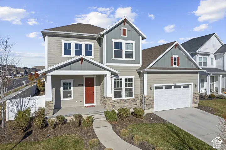 Two-story residence featuring a two-car garage, stone fa