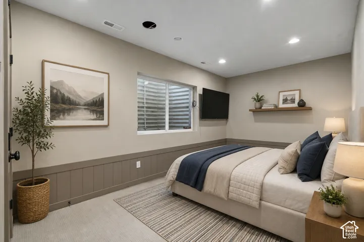 Recessed lighting, light-toned walls, and a window provide illumination