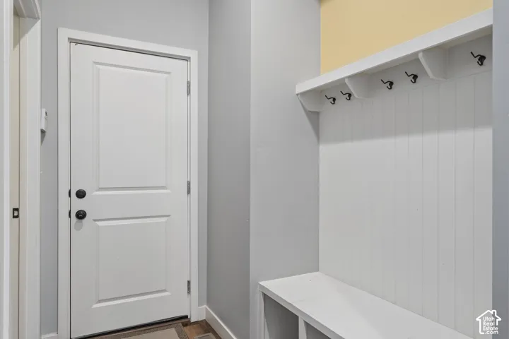 Built-in mudroom bench with cubby storage, beadboard paneling, integrated hooks, and overhead shelving