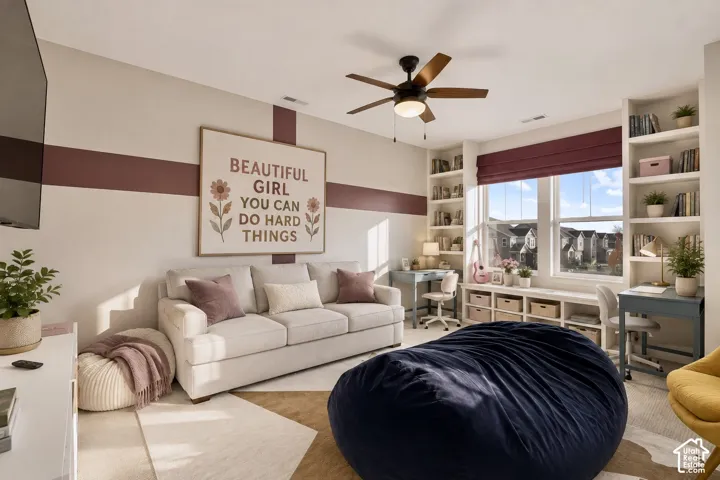 Built-in shelving flanking a large window, a ceiling fan with integrated lighting, and painted wall detailing
