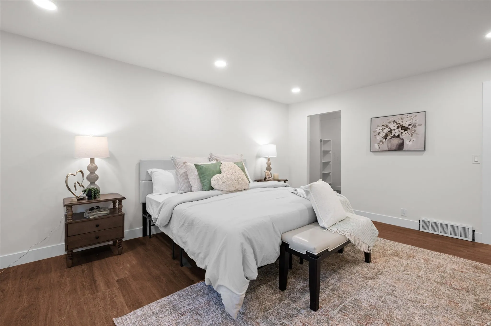 Bedroom featuring recessed lighting, wood-finish flooring, white baseboards, and a closet with built-in shelving