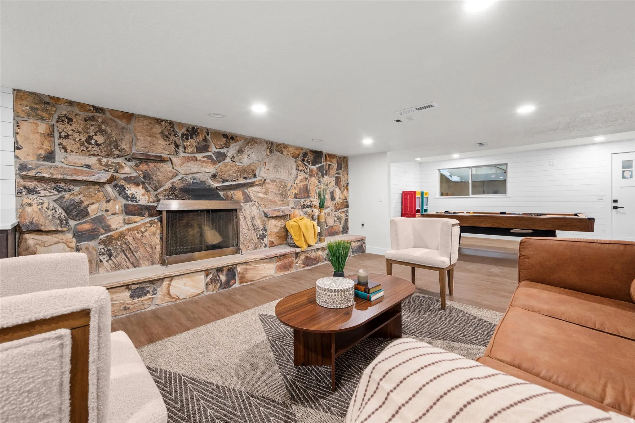 Expansive living area featuring a full stone-clad fireplace and hearth