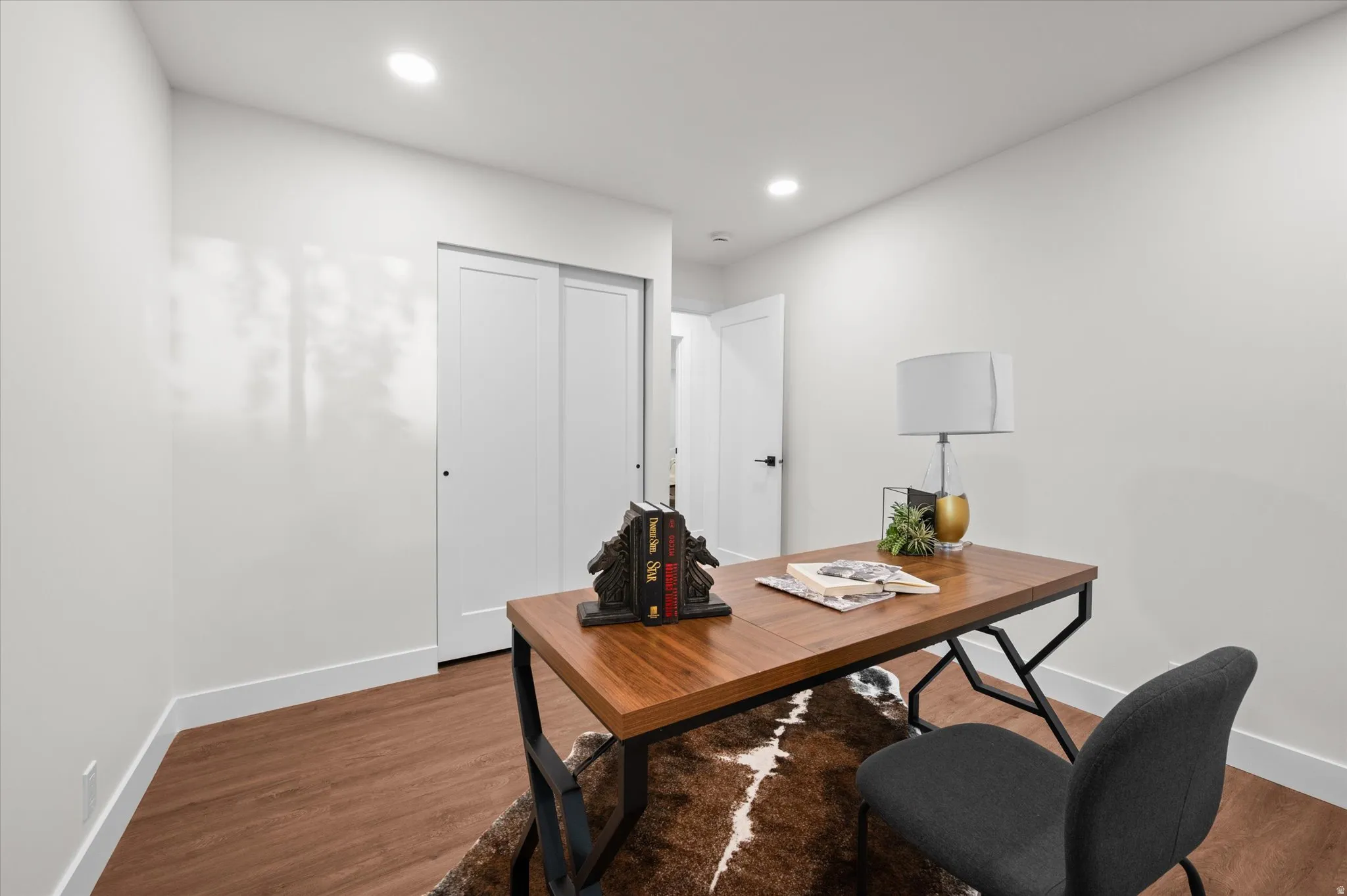 Versatile room featuring wood-finish flooring and recessed lighting