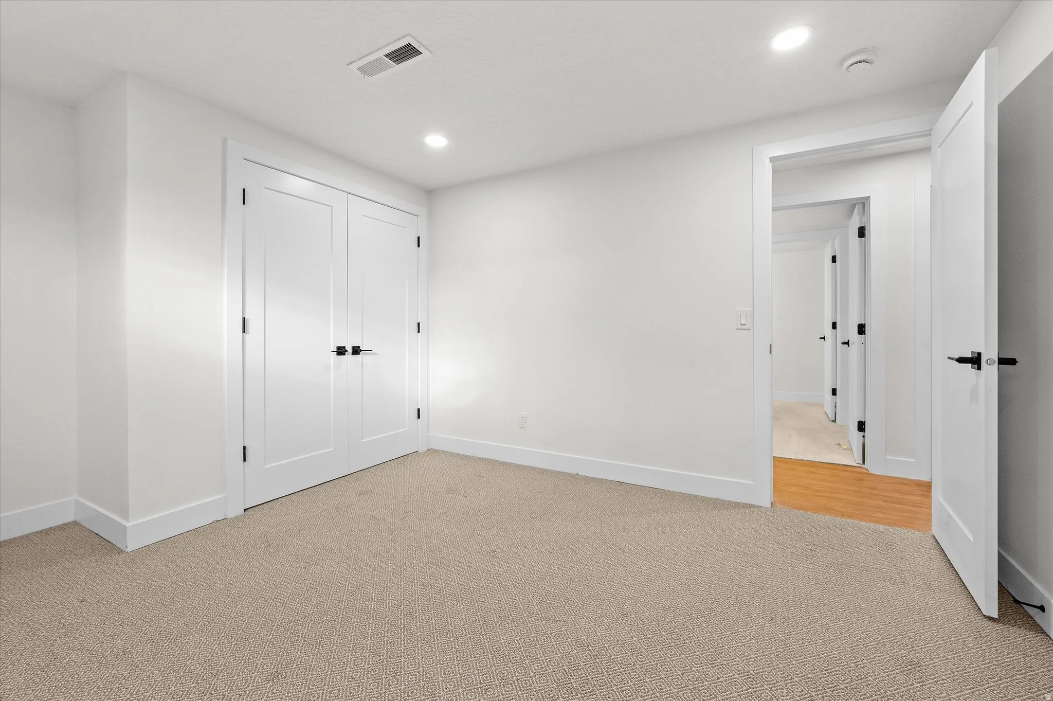 Bright interior room featuring neutral carpeting and white walls