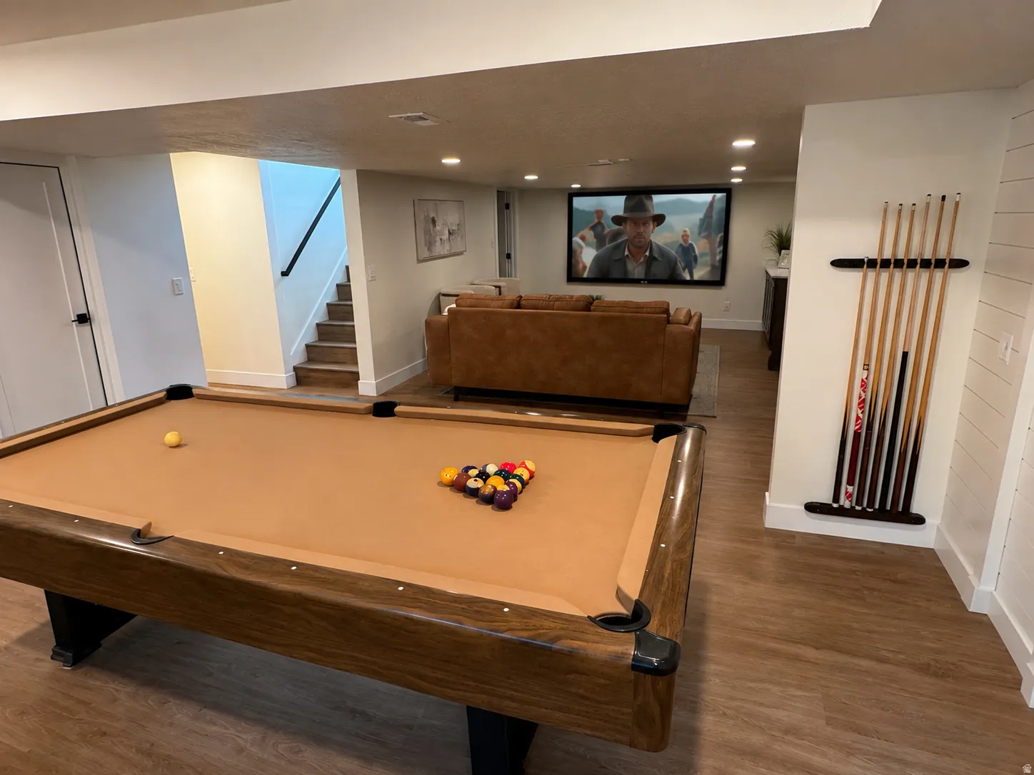 Recreation room featuring a built-in media screen, recessed lighting, wood-finish flooring, and shiplap wall accents
