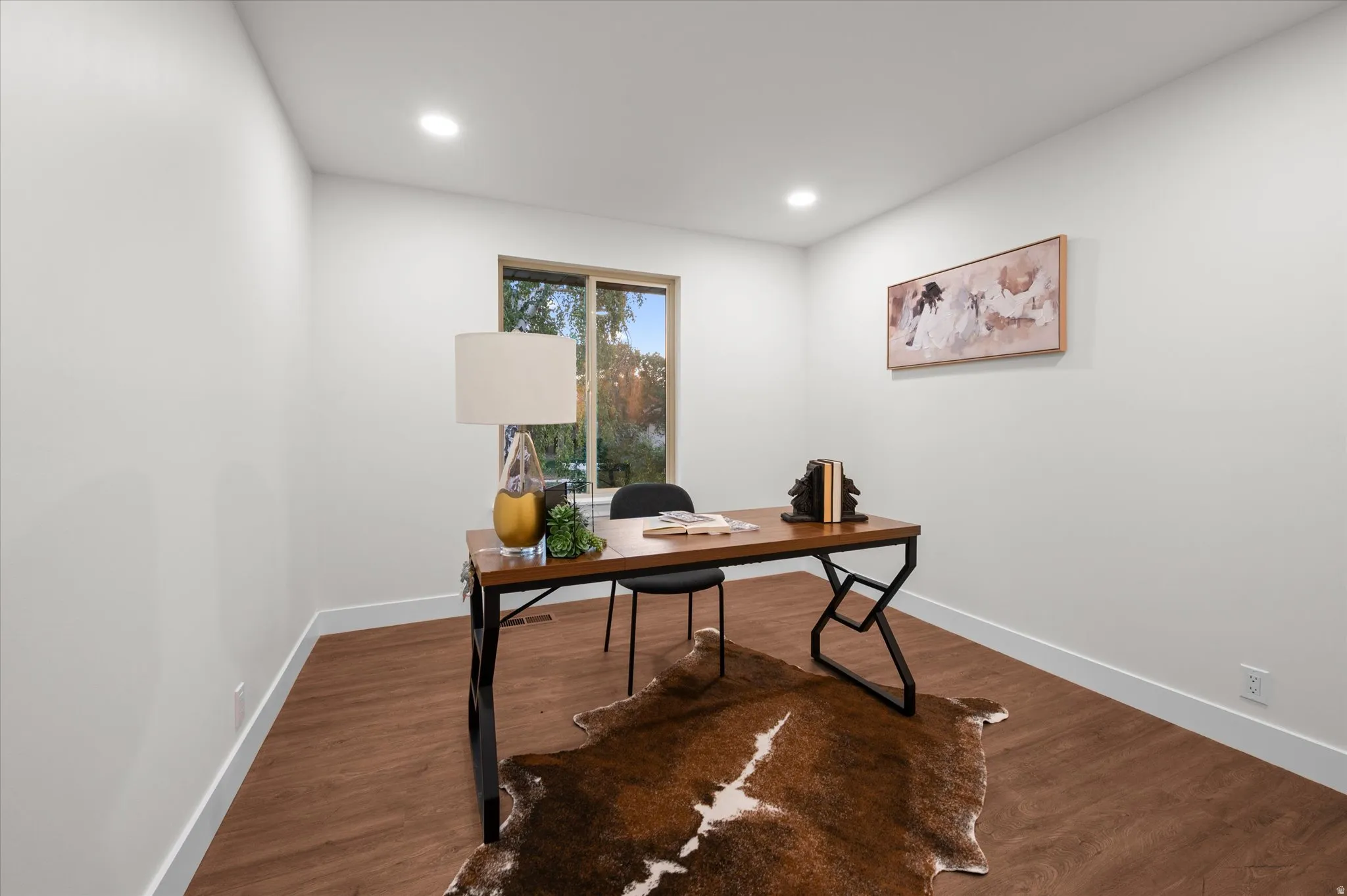 Room featuring wood-finish flooring, recessed ceiling lighting, and a large window
