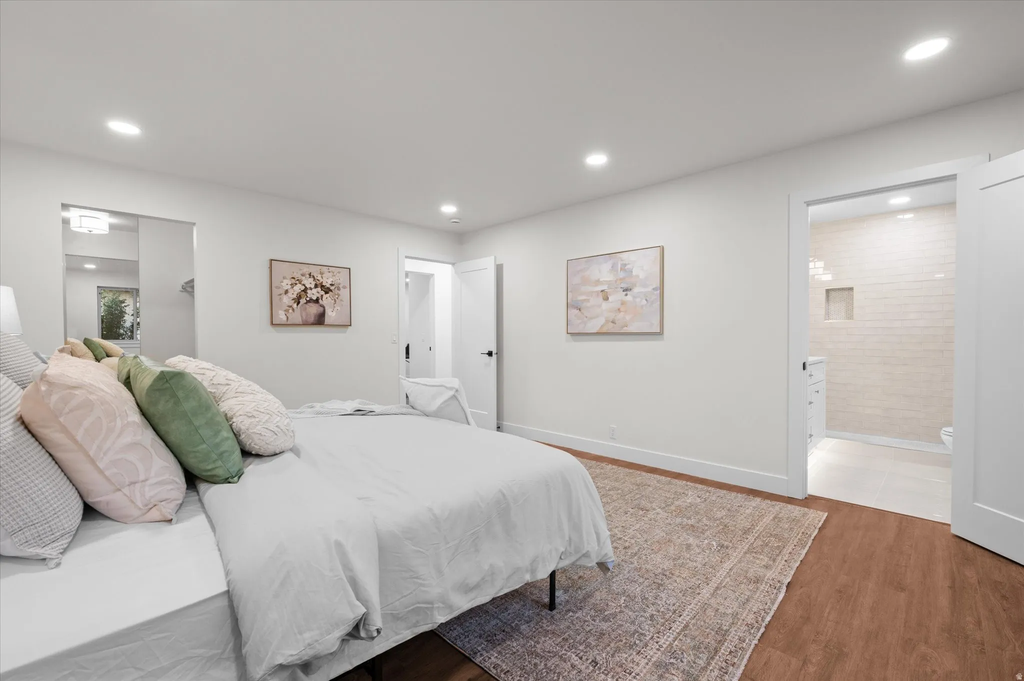 Bedroom featuring wood-finish flooring, recessed lighting, and a white interior door
