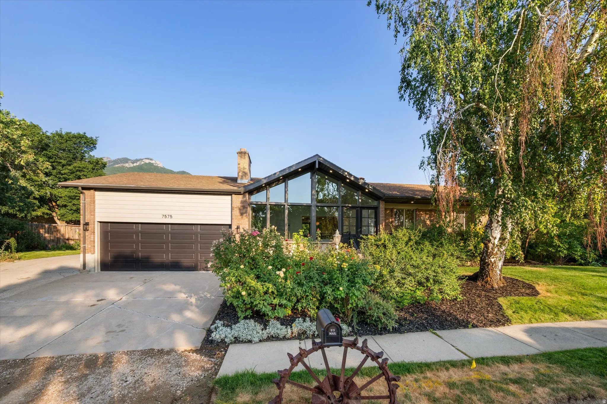 Brick facade residence featuring a prominent glass-enclosed atrium