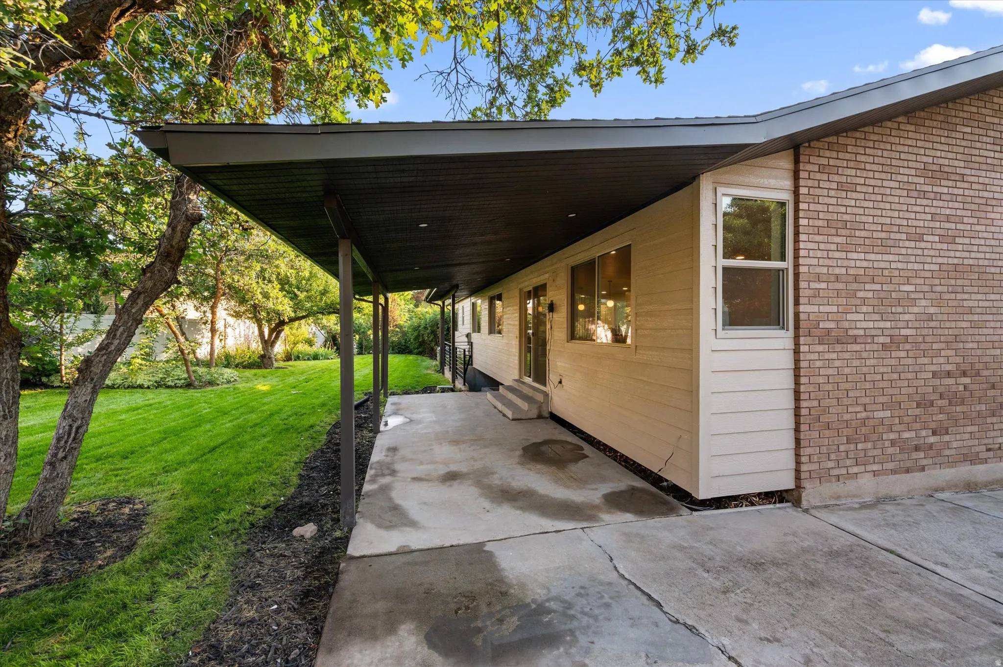 Covered patio with concrete surface, supporting posts, and dark soffit