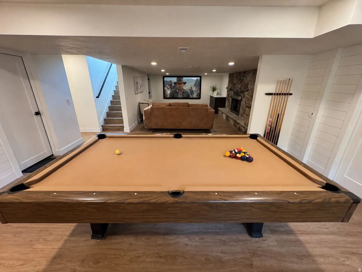 Recreation room featuring a pool table, stone-clad fireplace, and recessed lighting
