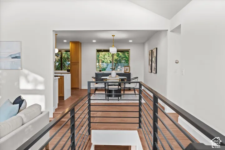 Modern interior featuring wood-finish flooring, a contemporary railing system, and recessed lighting
