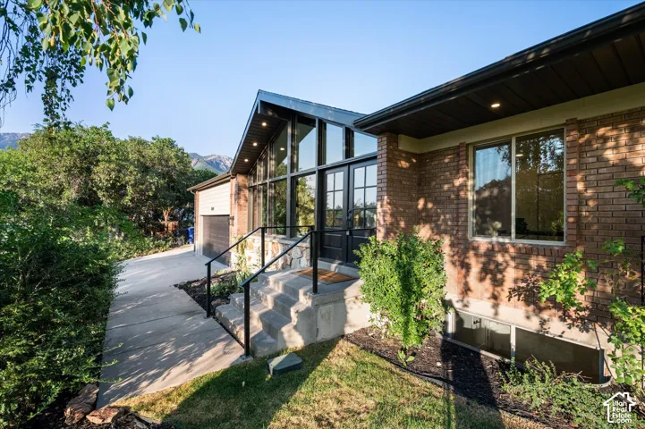 Contemporary residence with a striking glass-paneled entry and black-framed double doors
