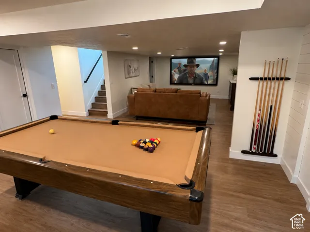 Recreation room featuring a built-in media screen, recessed lighting, wood-finish flooring, and shiplap wall accents