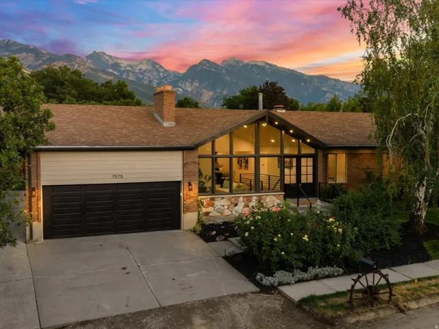 Ranch-style residence featuring a brick facade and a multi-panel garage door