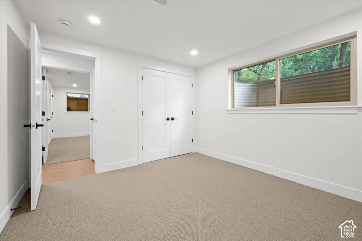 Carpeted room with a horizontal window featuring a window well