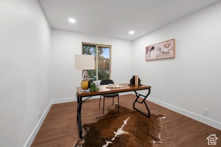 Room featuring wood-finish flooring, recessed ceiling lighting, and a large window