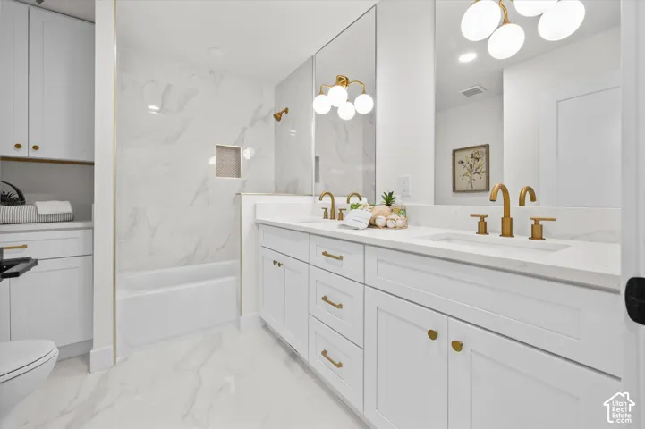 Dual vanity with quartz countertop, undermount sinks, and brushed gold fixtures