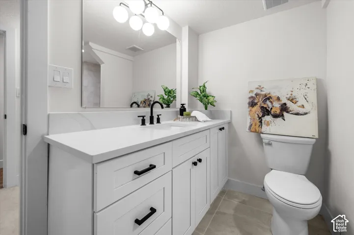 Bathroom featuring a white vanity with shaker-style cabinetry, black hardware, and a white countertop