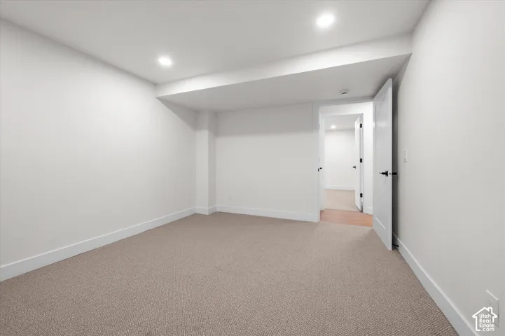 Spacious room featuring neutral carpet flooring, white walls, recessed lighting, and white trim