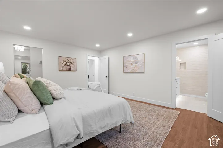 Bedroom featuring wood-finish flooring, recessed lighting, and a white interior door